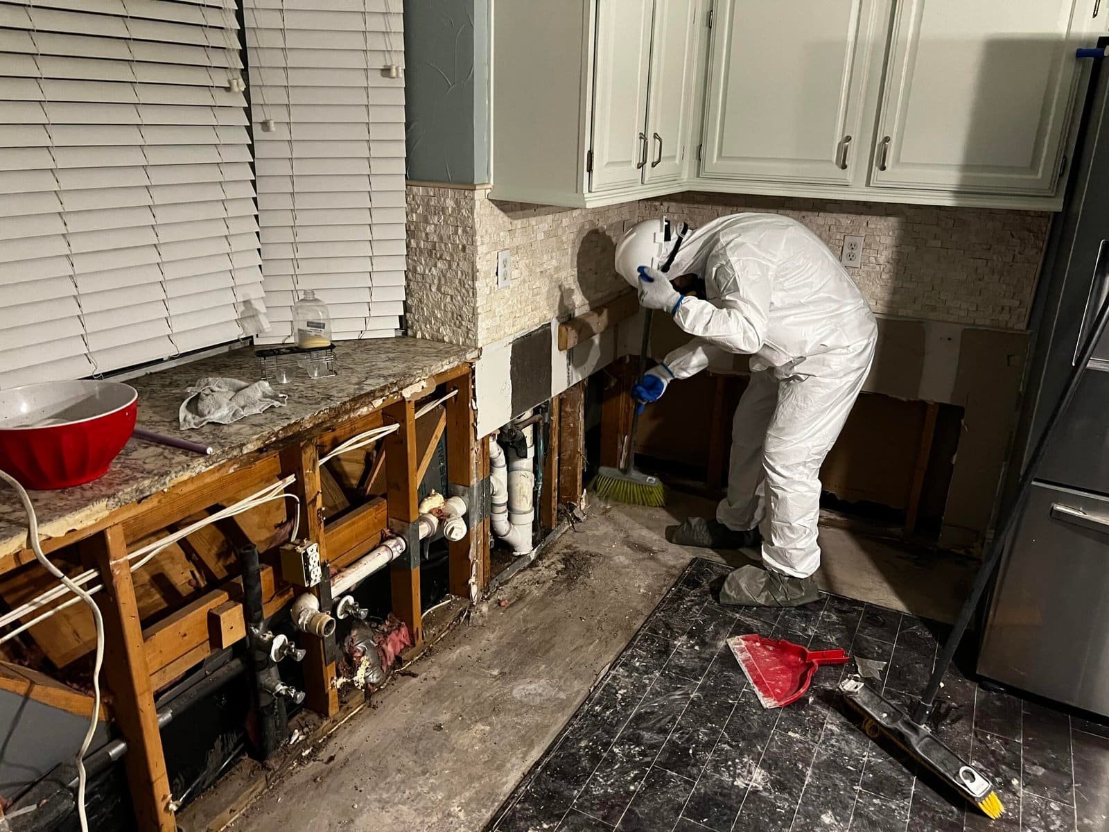IICRC-certified emergency restoration Dallas technician performing controlled remediation work inside a residential kitchen