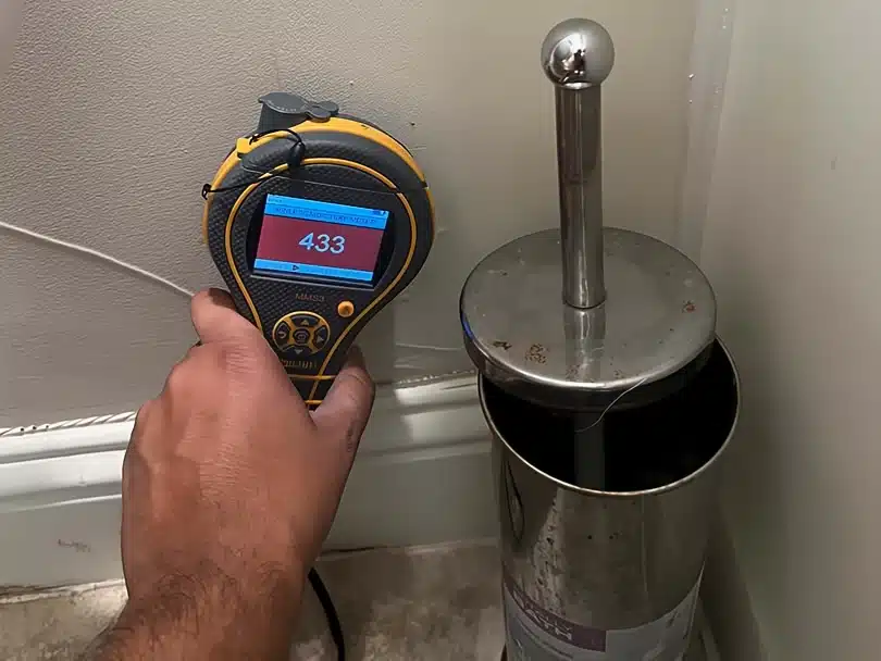 Protimeter moisture meter detecting wall moisture during Water Damage Restoration Plano inspection