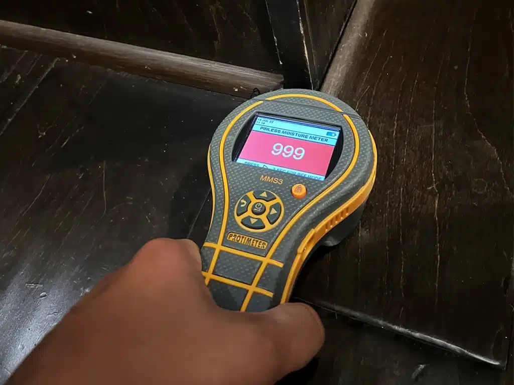 Water Damage Restoration Dallas Fort Worth Rushdry team using a Protimeter to detect moisture in hardwood floors
